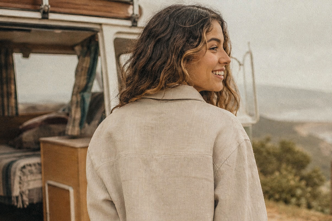 Woman standing by a camper van overlooking a scenic landscape wearing Hemp clothing